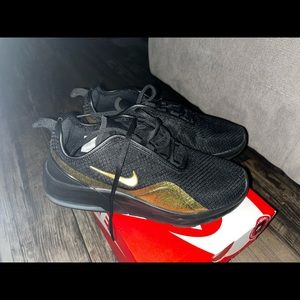 Women’s size 10 Nike Air Max Motion 2 black and gold in color